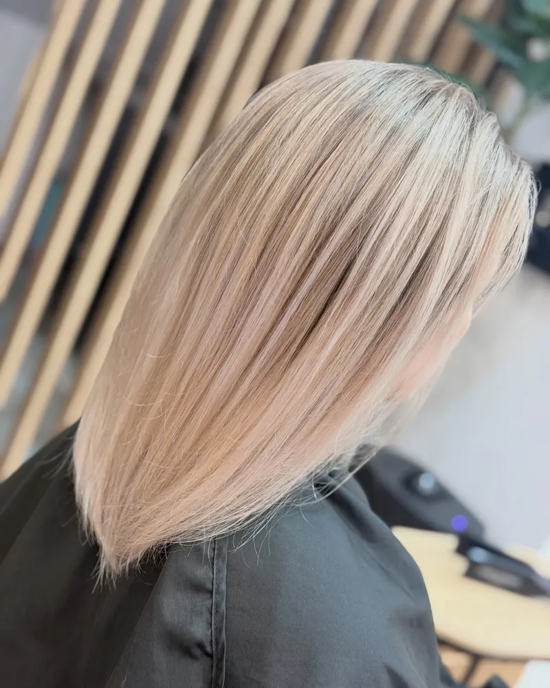 Beżowy blond do ramion, w tle dębowe lamele