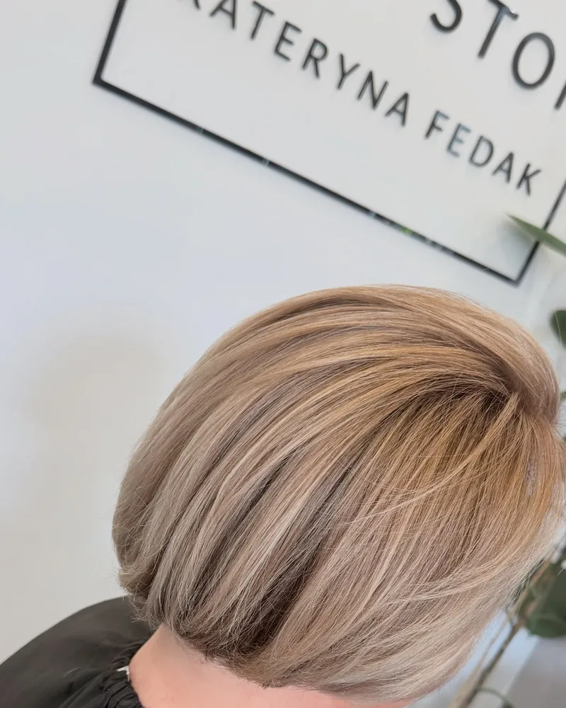 Krótki popielaty blond, w tle logo salonu