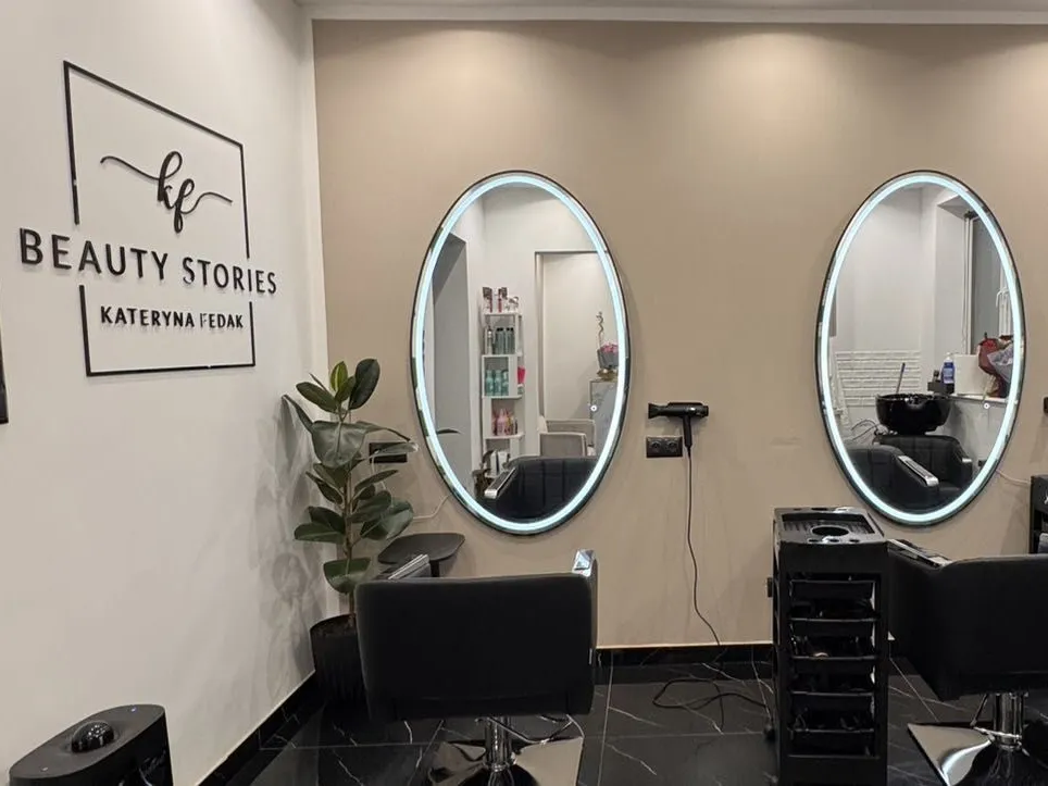 Salon w Gdyni: logo na ścianie i owalne lustra przy stanowiskach